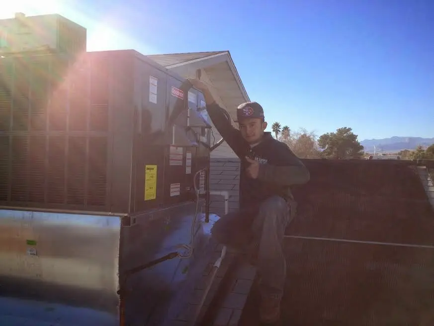 HVAC technician performing AC Tune-Up on a rooftop unit in Glendora